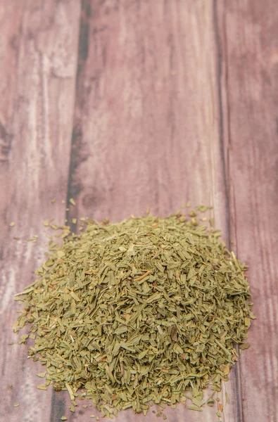 Dried tarragon herbs over wooden background