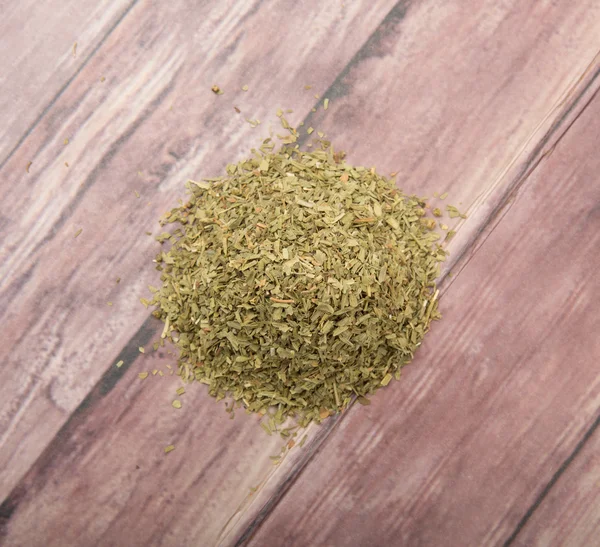 Dried tarragon herbs over wooden background