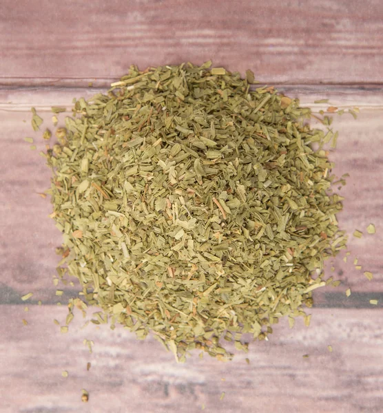 Dried tarragon herbs over wooden background