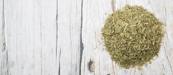 Dried tarragon herbs over wooden background