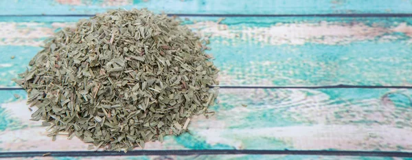 Dried tarragon herbs over wooden background