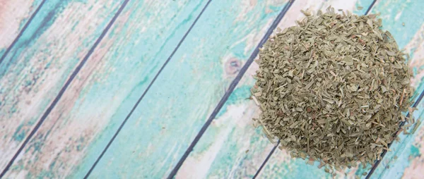 Dried tarragon herbs over wooden background