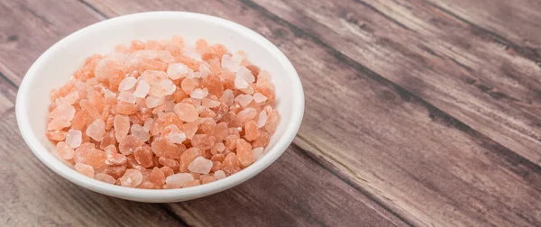 Himalayan rock salt over wooden background