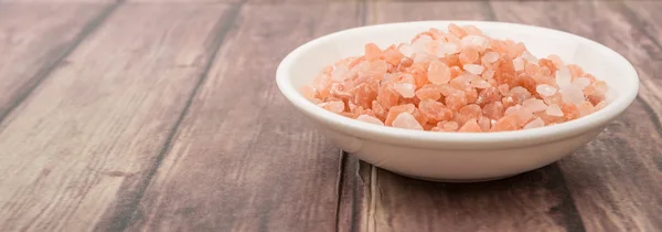 Himalayan rock salt over wooden background