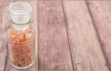 Himalaya kaya tuzu ahşap arka plan üzerinde cam şişe içinde