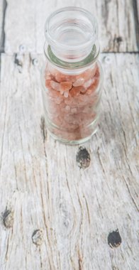 Himalaya kaya tuzu ahşap arka plan üzerinde cam şişe içinde