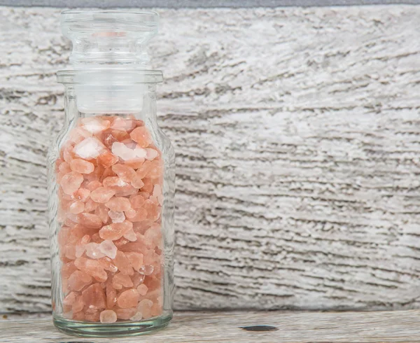 Himalaya kaya tuzu ahşap arka plan üzerinde cam şişe içinde