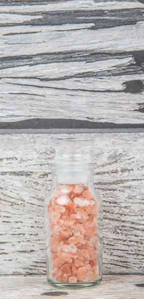 Himalaya kaya tuzu ahşap arka plan üzerinde cam şişe içinde