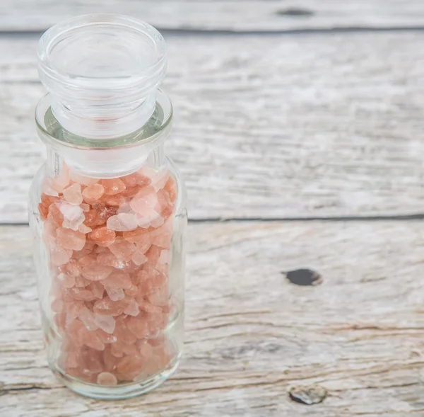 Himalaya kaya tuzu ahşap arka plan üzerinde cam şişe içinde