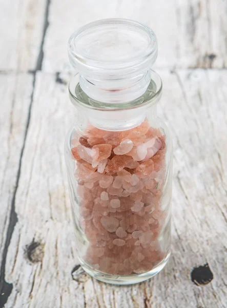 喜马拉雅山岩盐在玻璃小瓶在木制的背景 — 图库照片