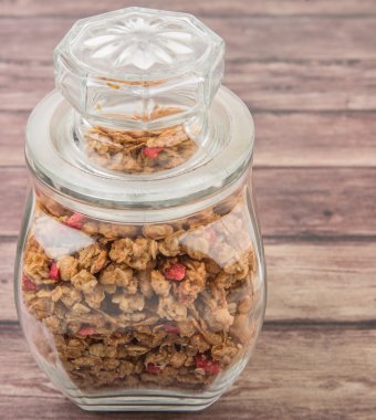 Kurutulmuş frambuaz adet cam ahşap arka plan üzerinde Mısır gevreği