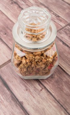 Kurutulmuş frambuaz adet cam ahşap arka plan üzerinde Mısır gevreği