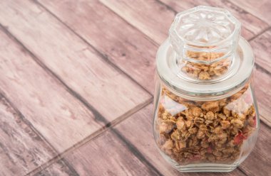 Kurutulmuş frambuaz adet cam ahşap arka plan üzerinde Mısır gevreği