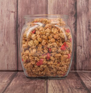 Kurutulmuş frambuaz adet cam ahşap arka plan üzerinde Mısır gevreği