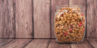 Kurutulmuş frambuaz adet cam ahşap arka plan üzerinde Mısır gevreği