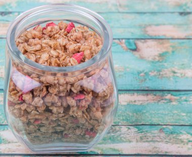 Kurutulmuş frambuaz adet cam ahşap arka plan üzerinde Mısır gevreği