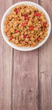 Kurutulmuş frambuaz adet ahşap arka plan üzerinde beyaz kase mısır gevreği