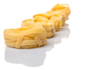 Beyaz arka plan üzerinde kurutulmuş tagliatelle makarna