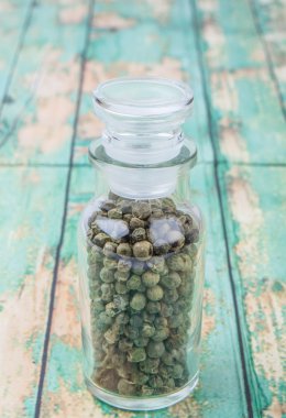 Yeşil peppercorns içinde cam şişe