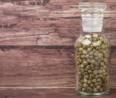 Yeşil peppercorns içinde cam şişe