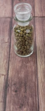 Yeşil peppercorns içinde cam şişe