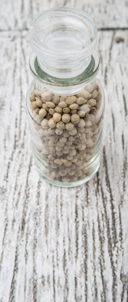 Grãos de pimenta branca em frasco de vidro — Fotografia de Stock