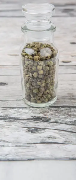 Grüne Pfefferkörner im Glasfläschchen — Stockfoto