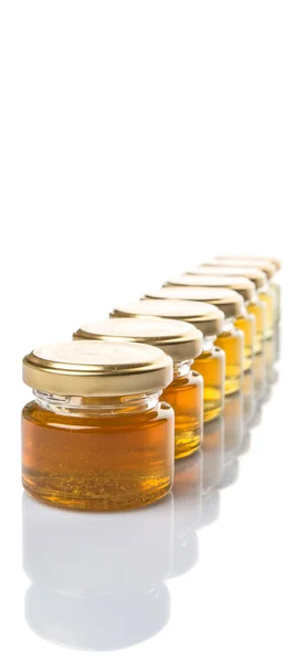 不同等级和颜色的蜂蜜在梅森罐子在白色背景 — 图库照片