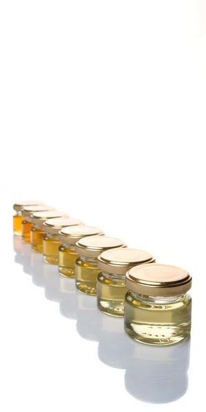 異なる等級と白い背景の上の石工の Jar ファイルの蜂蜜の色 — ストック写真