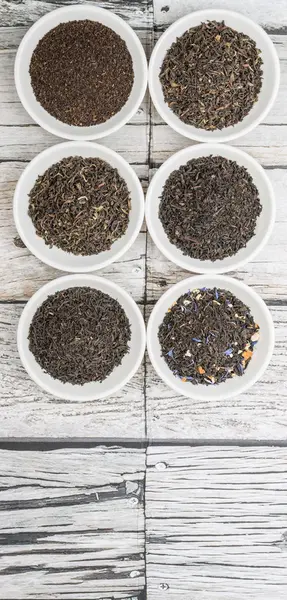 Lose Und Getrocknete Schwarze Teeblätter Weißen Schalen Über Holzhintergrund — Stockfoto
