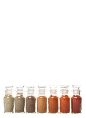 Soğuk toz, cayenne tozu, kırmızı biber tozu, karabiber toz, beyaz biber tozu, karabiber toz Beyaz arka plan üzerinde cam şişe içinde ürün yelpazesine