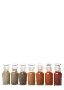 Soğuk toz, cayenne tozu, kırmızı biber tozu, karabiber toz, beyaz biber tozu, karabiber toz Beyaz arka plan üzerinde cam şişe içinde ürün yelpazesine