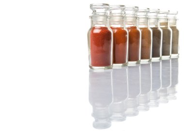 Soğuk toz, cayenne tozu, kırmızı biber tozu, karabiber toz, beyaz biber tozu, karabiber toz Beyaz arka plan üzerinde cam şişe içinde ürün yelpazesine