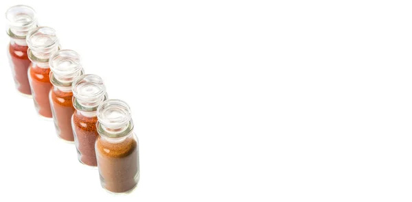 各种各样的辣椒 辣椒粉和卡宴粉在白色背景下的玻璃小瓶 — 图库照片