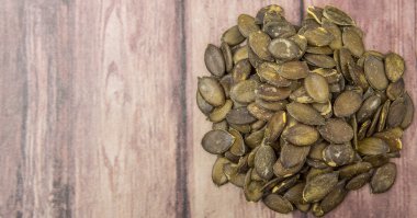 Ahşap arka plan üzerinde kavrulmuş kabak çekirdeği