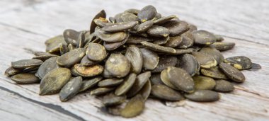 Ahşap arka plan üzerinde kavrulmuş kabak çekirdeği