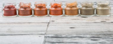 Sıcak ve baharatlı baharat tozu, kırmızı toz, soğuk toz, biber tozu, kırmızı biber tozu, karabiber ve küçük mason kavanoza ahşap arka plan üzerinde beyaz biber tozu