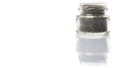 Küçük mason kavanoza beyaz arka plan üzerinde siyah haşhaş tohumu