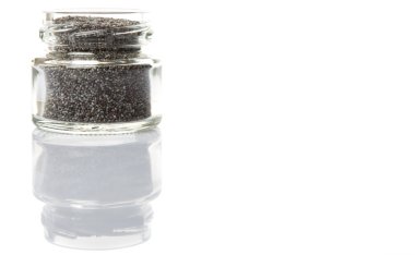 Küçük mason kavanoza beyaz arka plan üzerinde siyah haşhaş tohumu