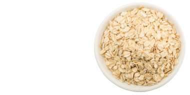 Beyaz arka plan üzerinde beyaz kase çiğ yulaf gevreği