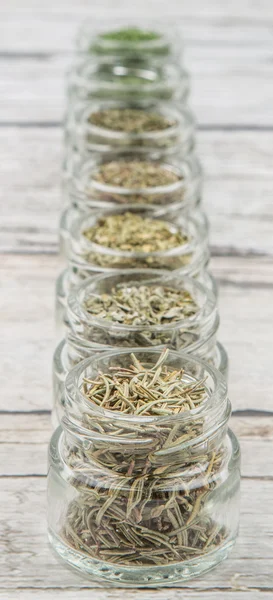 Kurutulmuş maydanoz, roka, mercanköşk, dereotu, kafiye, biberiye ve basil otlar ahşap arka plan üzerinde mason kavanoza