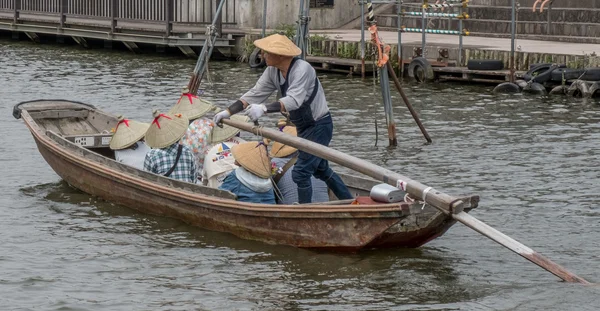 Locals and tourist riding a wooden boat — Stock Photo, Image