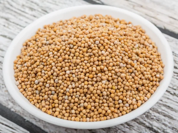 Mustard seeds in the white bowl — Stock Photo, Image