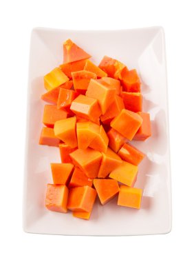 Beyaz arka plan üzerinde beyaz tabakta ısırık büyüklüğünde papaya meyve