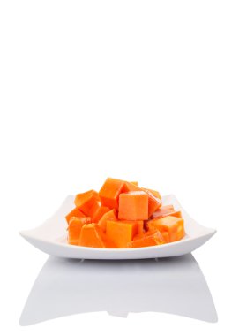 Beyaz arka plan üzerinde beyaz tabakta ısırık büyüklüğünde papaya meyve