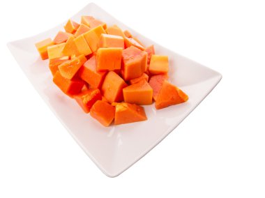 Beyaz arka plan üzerinde beyaz tabakta ısırık büyüklüğünde papaya meyve