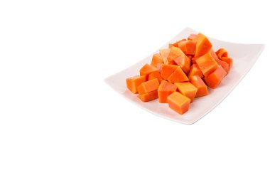 Beyaz arka plan üzerinde beyaz tabakta ısırık büyüklüğünde papaya meyve