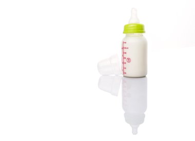 beyaz zemin üzerinde bir biberon süt