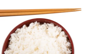 bir kase pilav ve beyaz zemin üzerine çubuk çifti