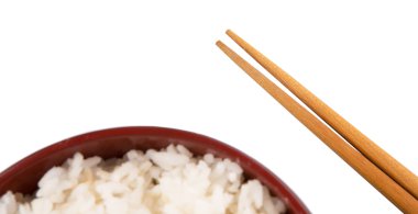 bir kase pilav ve beyaz zemin üzerine çubuk çifti